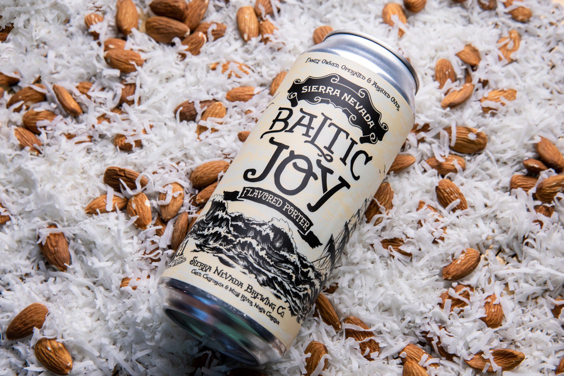 A can of Baltic Joy Porter resting on a bed of almonds and coconut